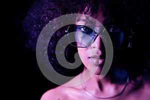 Portrait of young alluring mixed race girl in neon light. Fashion, glamour, model concept. Seductive woman with make-up