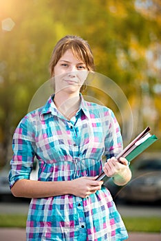 Portrait of young alluring woman holding education