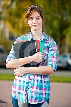 Portrait of young alluring woman holding education