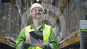 Portrait of young american man using tablet while working in industrial warehouse.