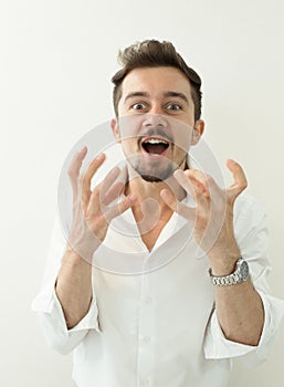 Portrait of young angry man. Angry shouting man at somebody. Screaming man gesturing with hands on white background.