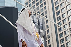 Portrait of Young Arab middle eastern man standing with looking to the sky, Muslim engineer man walking in downtown