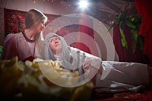 Portrait of young arabian muslim couple in traditional clothes in cozy red room. Fhoto shoot in easten style with male