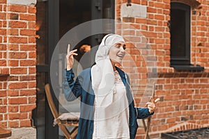 Portrait of young arabian muslim woman listening music with headphone and dancing. Feminism, woman independence and