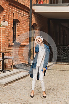 Portrait of young arabian muslim woman listening music with headphone and dancing. Feminism, woman independence and