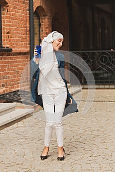 Portrait of young arabian muslim woman listening music with headphone and dancing. Feminism, woman independence and