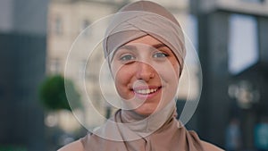 Portrait of the young arabian woman wearing hijab smiling looking at the camera on the business centre background