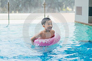 Portrait of Young asian boy kid child laughing in a swimming pool. Sunlight filter process