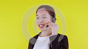 Portrait young asian business woman call center wearing headset on yellow background.