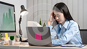 Portrait of young asian business woman feeling stress and tired from work sitting on the chair about constant headaches a migraine