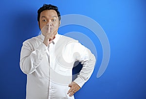 Portrait of young Asian businessman asking to be quiet