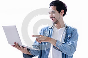 Portrait of young Asian businessman, entrepreneur pointing to the laptop with happiness and triumph of the business goal in white