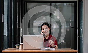 Portrait young asian businesswoman beautiful charming smiling and talking on the mobile phone in the office. female