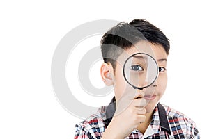 Portrait of a young asian child looking through a magnifying gla