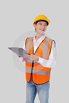 Portrait young asian engineer man wearing helmet looking document or report on clipboard isolated white background