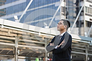 Portrait young Asian executive businessman in suit looking at far away outdoors. Business vision concept