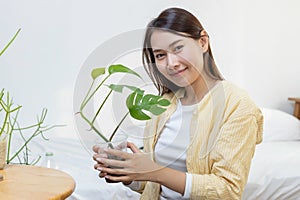 Portrait of young asian female smiling holding potted plants made from recycled plastic bottles. Bringing plastic bottles or waste