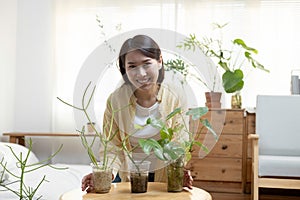 Portrait of young asian female smiling with potted plants made from recycled plastic bottles. Bringing plastic bottles or waste