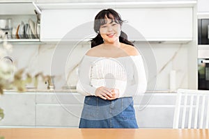 Portrait of young asian girl in the interior of modern kitchen
