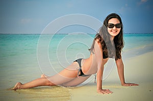 Portrait of young asian looking woman lie down in bikini at tropical beach at Maldives