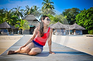 Portrait of young asian looking woman sitting near restaurant at beautiful tropical beach at Maldives