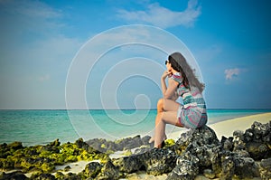 Portrait of young asian looking woman thinking at tropical beach at Maldives