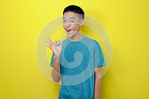 Portrait of Young Asian man feeling optimistic showing ok gesture