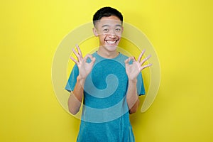 Portrait of Young Asian man feeling optimistic showing ok gesture with both hand