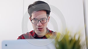 Portrait of young asian man student using laptop to study at home. Distance learning concept