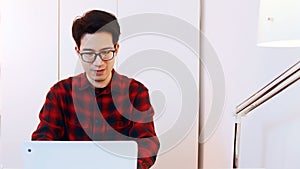 Portrait of young asian man student using laptop to study at home. Distance learning concept