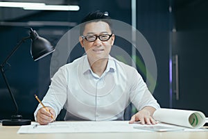Portrait of young Asian man wearing glasses, designer, architect, looking at camera, smiling