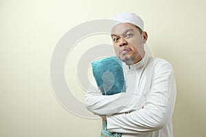 Portrait of young Asian muslim man pointing at his wristwatch