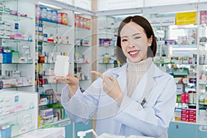 Portrait of young asian pharmacist pill bottle mockup at qualified pharmacy