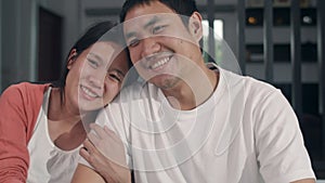 Portrait young Asian Pregnant couple relax toothy smile looking to camera at home. Mom and Dad feeling happy funny peaceful while