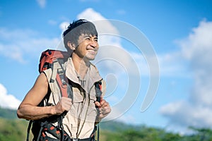 Portrait of a young Asian Smiling wanderer with backpack walking outdoors in nature, Travelers enjoy relaxing time in nature with