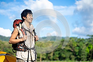 portrait of a young Asian Smiling wanderer with backpack walking outdoors in nature, Travelers enjoy relaxing time in nature