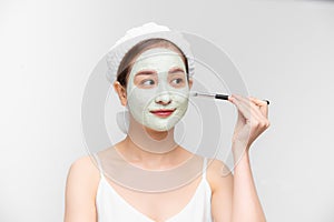Portrait of young Asian woman applying clay mask on her face. Spa and wellness, skin care product concept