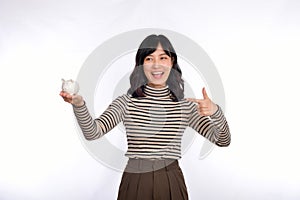 Portrait of young Asian woman casual uniform holding white piggy bank isolated on white background, Financial and bank saving