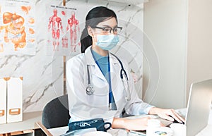 Portrait of young asian woman doctor healthcare professional in blue uniform standing in hospital.. Doctor using tablet for work.