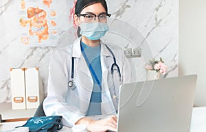 Portrait of young asian woman doctor healthcare professional in blue uniform standing in hospital.. Doctor using tablet for work.