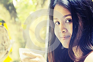 Portrait young asian woman drinking hot green tea latte in coffee shop.