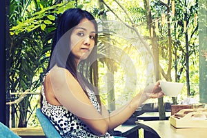 Portrait young asian woman drinking hot green tea latte in coffee shop.