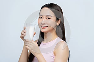 Portrait young asian woman drinking milk from the glass isolated over white background