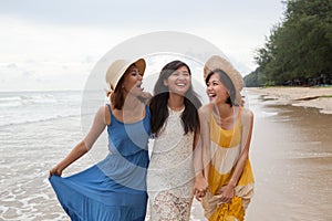 portrait of young asian woman with happiness emotion wearing beautiful dress walking on sea beach and laughing joyful use for