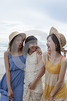 portrait of young asian woman with happiness emotion wearing beautiful dress walking on sea beach and laughing joyful use for