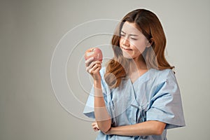 Portrait of young Asian woman holding apple feeling curious about the hygiene or nutrition of food with copy space, the concept of