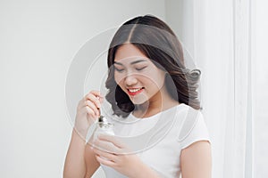 Portrait of young asian woman at home eating yogurt