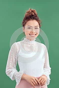 Portrait of young Asian woman loking at the camera over green background