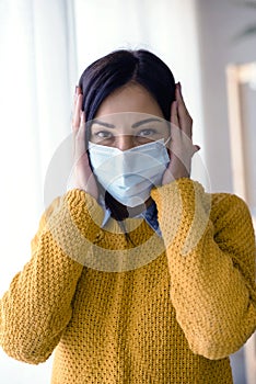 Portrait of young Asian woman,  putting on a medical surgical disposabhttpsle face mask to prevent infection