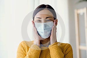 Portrait of young Asian woman,  putting on a medical surgical disposabhttpsle face mask to prevent infection